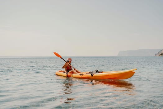 Kayak sea woman. Happy attractive woman with long hair in red swimsuit, swimming on kayak. Summer holiday vacation and travel concept