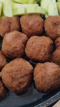 green zucchini and cutlets meatballs in a frying pan, homemade food, cooking. High quality photo