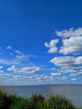 Clouds float over the Dniester estuary. Sunny weather and light breeze.