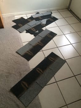 Shingles that Blew off My Roof in a Storm now on the Floor Inside. High quality photo