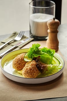 Perfectly golden-brown breaded ground chicken patties served with side of creamy mashed potatoes, fresh crispy lettuce and cucumber slices for lunch. Concept of wholesome and satisfying meal