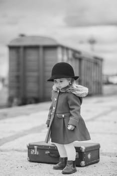 Retro photo of a baby girl who is waiting for a train.