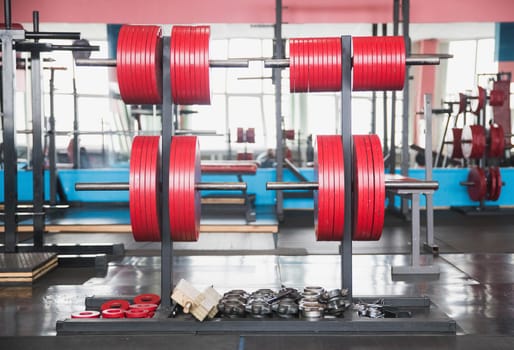 Plates to the barbell in the gym.