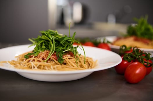 Food background with classic Italian cuisine dish. Pasta capellini with tomatoes, arugula leaves and parmesan cheese. Copy advertising space. Classic Italian cuisine dish.