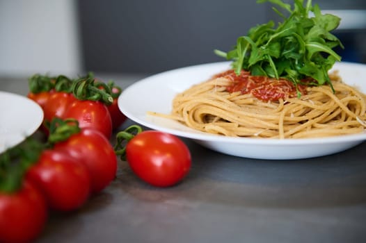 Food background. Still life with a white plate with Italian spaghetti capellini with tomato sauce, garnished with