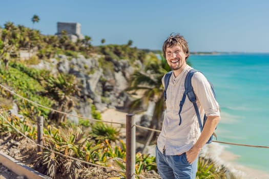 Man tourist enjoying the view Pre-Columbian Mayan walled city of Tulum, Quintana Roo, Mexico, North America, Tulum, Mexico. El Castillo - castle the Mayan city of Tulum main temple.