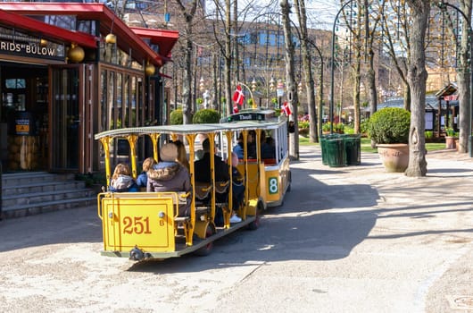 A childrens train ride rides through the Tivoli amusement park in Copenhagen, Denmark - April 21, 2024