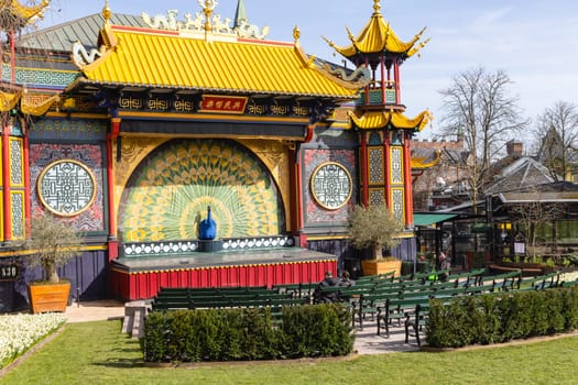 Chinese-style pantomime theatre with large peacock and empty theater seats. Tivoli Gardens, Copenhagen, Denmark - April 3, 2024