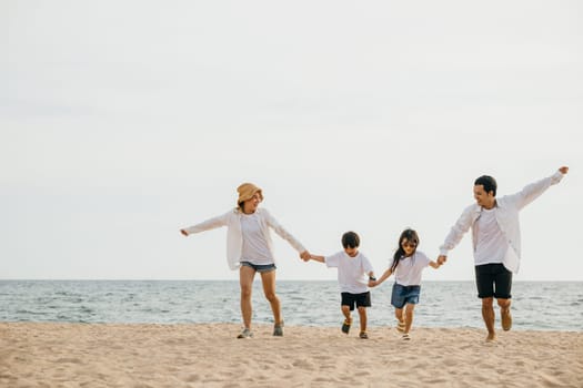 Happy parents hand in hand run and jump with their children on the beach embodying the joy and togetherness of a family vacation by the sea. tourism day concept