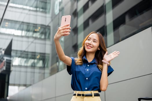 Stylish millennial woman with a bright smile, taking a selfie with her mobile phone. Youthful lady using her handheld device to capture a perfect moment in the city.