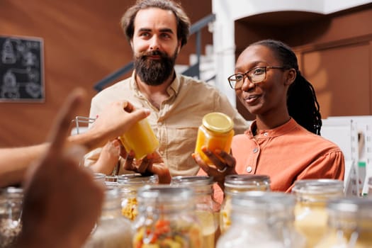 Vibrant portrayal of man and woman selecting fresh and healthy food items, highlighting the connection between sustainable choices and nutritious lifestyle. Young couple looking at honey jars.