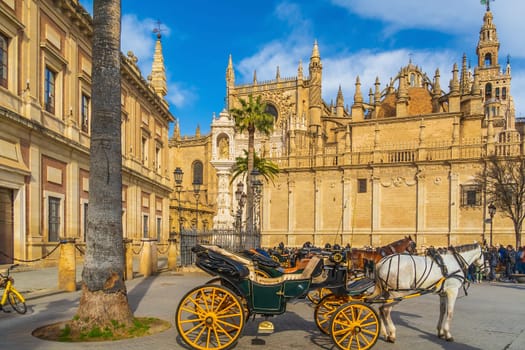 Horse carriage in front of Giralda tower and Seville Cathedral in downtown Spain