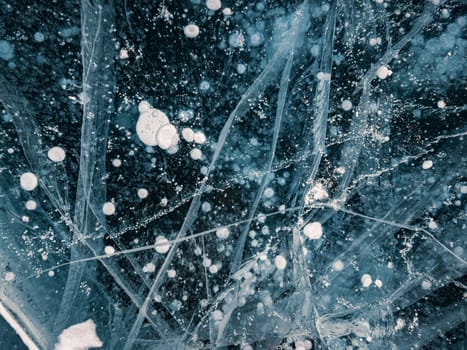 Blue snowy cracked ice of the lake Baikal. Winter landscape of frozen Baikal. Popular tourist spot