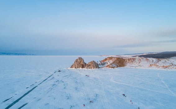 Aerial shot of Shamanka rock and Cape Burkhan on Olkhon. Beautiful view on frozen Baikal. Panoramic winter landscape. Popular touristic destination