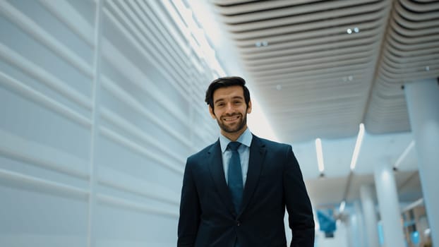 Smiling business man looking at camera while standing at white background. Closeup of successful man smiling at camera while wearing business suit. Happy executive manager look at camera. Exultant.