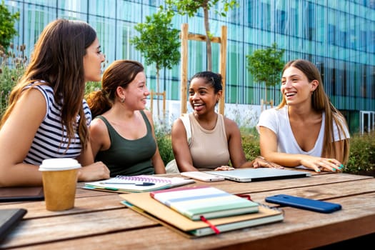 Group of multiracial female college student friends laughing, enjoying time together outdoor college campus.Education and friendship concept.