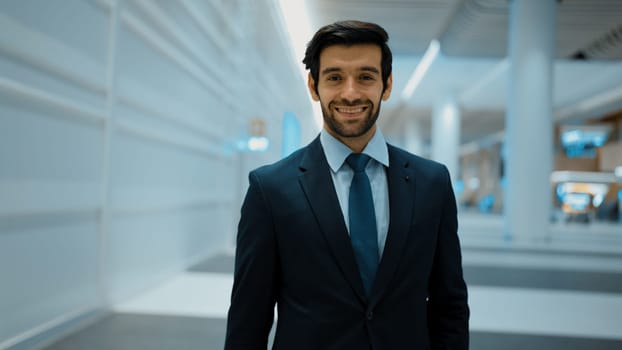 Smiling business man looking at camera while standing at white background. Closeup of successful man smiling at camera while wearing business suit. Happy executive manager look at camera. Exultant.