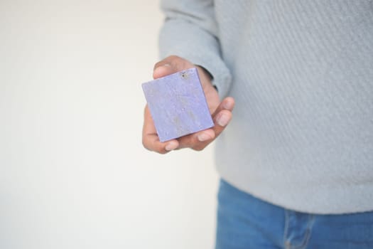 hand holding a natural soap bar with copy space ,