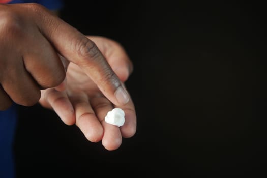 Close up of man using moisturizing cream on hand.