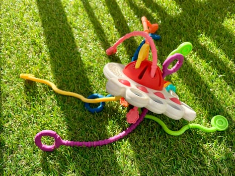 A bright children's toy lies on artificial grass. High quality photo