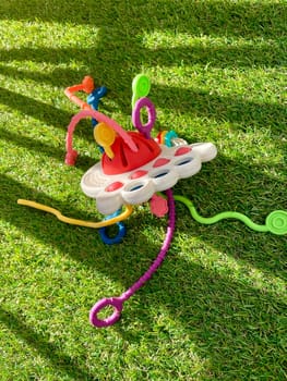 A bright children's toy lies on artificial grass. High quality photo