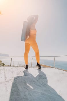 Fitness woman sea. Outdoor workout on yoga mat in park near to ocean beach. Female fitness pilates yoga routine concept. Healthy lifestyle. Happy fit woman exercising with rubber band in park.