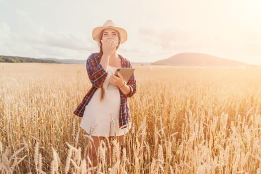 Woman farmer walks through a wheat field at sunset, touching green ears of wheat with his hands. Hand farmer is touching ears of wheat on field in sun, inspecting her harvest. Agricultural business.