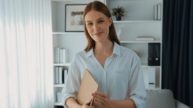 Friendly psychologist woman in clinic office professional portrait with smile and holding clipboard for patient to visit psychologist. The experienced and prim confident psychologist