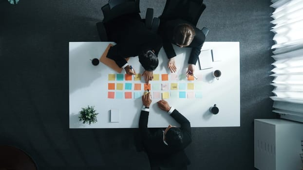 Top view of professional business team planning marketing strategy. Skilled group of diverse business people writing and sharing creative idea on sticky notes and discuss about plan. Directorate.