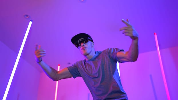 Low angle camera of caucasian dancer wearing fancy glasses and performing break dancing. Attractive man shown energetic performance and movement while looking at camera with confident. Regalement.