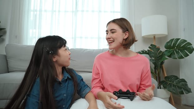 Caucasian smart mom playing game together with daughter for winning or clear game while planning strategy. Attractive mother and daughter spend time together while sitting at living room. Pedagogy.