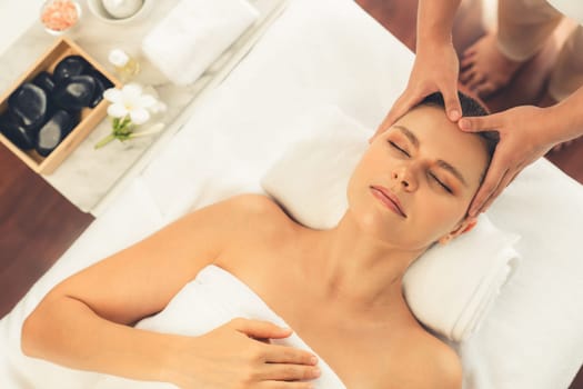 Panorama top view of woman enjoying relaxing anti-stress head massage and pampering facial beauty skin recreation leisure in dayspa modern light ambient at luxury resort or hotel spa salon. Quiescent