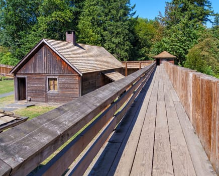 An old wooden fortified wall with a residential house in the inner yard.