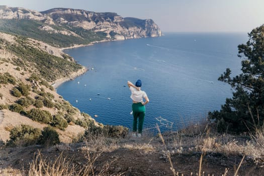 Happy woman standing with her back in nature in summer with open hands posing with mountains. Woman in the mountains, eco friendly, summer landscape active rest.