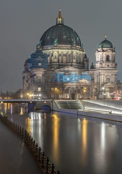 Berlin, Germany - Dec 19, 2023 - Picturesque view of The historic berlin cathedral building with a bridge over the river Spree at dusk. Berlin Cathedral Berliner Dom in Berlin, Space for text, Selective focus.