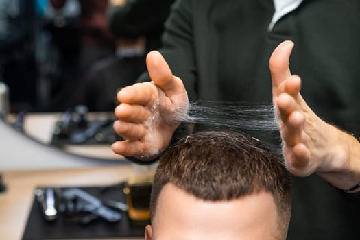 Barber expertly styling a clients hair with skilled hands in the barbershop.