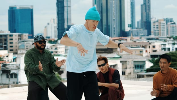 Professional break dance team practice B-boy dance while multicultural friends at rooftop. Young modern dancing group doing hip hop movement. Style,fashion,action. Outdoor sport 2024. Endeavor.