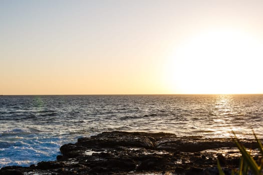 Evening scene on sea, stones, calm ocean.