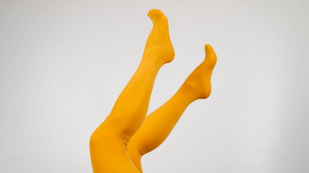 Female legs in ocher tights on a white background. Copy space