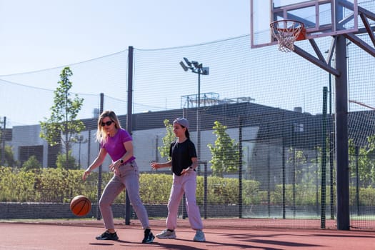 A Happy mother and child daughter outside at basketball court. High quality photo