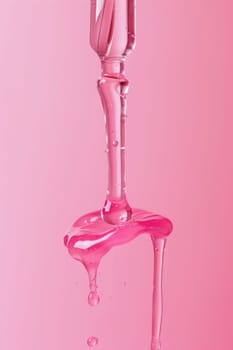 Pink nail polish bottle with liquid drop beauty and fashion concept closeup shot