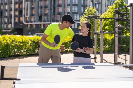 Kid playing table tennis outdoor with family. High quality photo