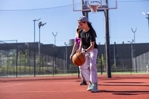 A Happy mother and child daughter outside at basketball court. High quality photo