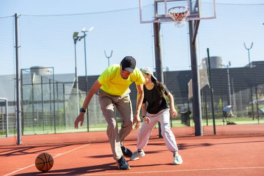 A father and daughter playing basketball in the park. High quality photo