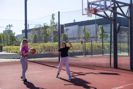 Mother and daughter playing basketball. High quality photo