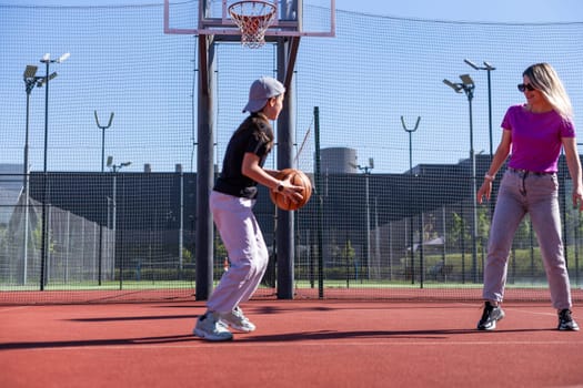 A Happy mother and child daughter outside at basketball court. High quality photo