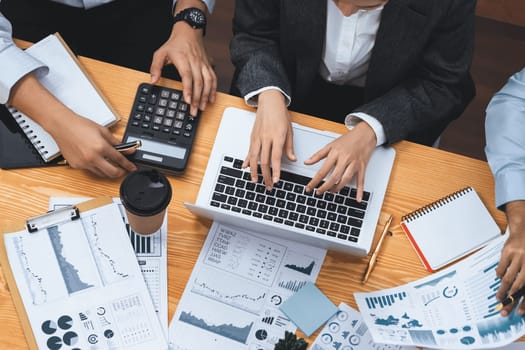 Multiracial analyst team use BI Fintech software to analyze financial data on meeting table. Financial dashboard data display on laptop screen with analyzed chart for marketing indication. Concord