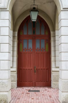 tall vintage brown wooden door with classic archway