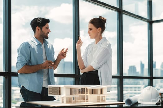 Professional architect engineer team discussing about house construction. Expert businesspeople sharing and brainstorming idea about house design. Working together. Skyscraper. Tracery.