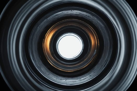 A digital representation of a camera lens interior, with a detailed view of glass and metal elements, set against a dark backdrop.